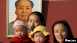 资料照:两名中国妇女抱着她们的孩子在北京天安门毛泽东画像前留影。(2015年11月2日)