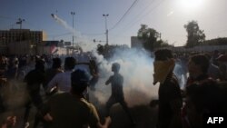 Những người ủng hộ Giáo sĩ Moqtada al-Sadr ném đạn hơi cay vào các lực lượng an ninh trong cuộc đụng độ sau khi người biểu tình xâm nhập vào Khu vực Xanh ở Baghdad, Iraq, ngày 20/5/2016.