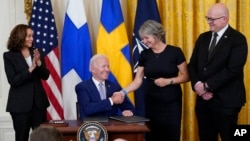 美国总统拜登在芬兰和瑞典驻美大使见证下正式签署美国支持两国加入北约组织的批准书。(2022年8月9日)