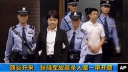 中央电视台播放的画面显示垮台的中国政治人物薄熙来的妻子谷开来和薄家勤务人员张晓军被带入中国东部的合肥市中级人民法院,他们被控害死了英国商人海伍德(2012年8月9日)