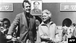 1974年美国驻北京联络处主任乔治·布什(老布什)和夫人骑自行车抵达北京天安门前。