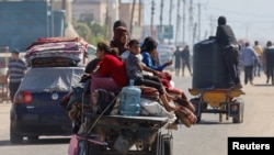 2024年5月9日,以色列军队在加沙地带南部城市东部发动地面和空中行动后,巴勒斯坦人乘坐畜力车逃离拉法。(路透社照片)