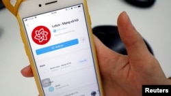 资料照片:2019年9月17日,越南一名用户在河内打开越南的新社交媒体应用程序Lotus。(路透社照片)