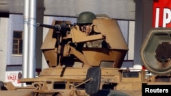在迪亚巴克尔一条主要街道上,一名土耳其陆军士兵守卫在机关枪后面。(2014年10月9日)