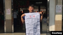 从中国大陆到台湾申请政治庇护的张文手持乞讨说明。(温起锋提供)