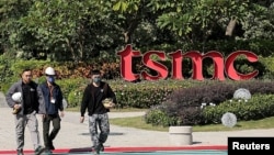 台湾工人走过台南科学园区的台积电标识。(2024年11月21日)