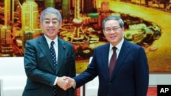 新华社照片: 中国国务院总理李强(右)2024年12月25日星期三在北京人民大会堂会见日本外务大臣岩屋毅。