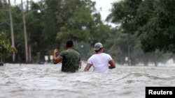 飓风“巴里”过后,路易斯安那州的人们艰难地穿过被洪水淹没的街道。(2019年7月13日)