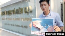 Nguyễn Thành Nhân cầm tấm biển: “Học sinh, sinh viên, không phải là chuột bạch” trước cổng Bộ Giáo dục và Đào tạo.