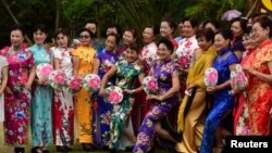 中国海南省琼海,国际妇女节前夕,旗袍秀中的妇女摆姿势拍照。(2018年3月7日)