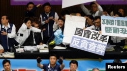 资料照片:台湾最大反对党国民党的立法委员试图阻挡民进党立法委员投掷的塑料袋,其中一些塑料袋上写有 “垃圾”字样。(2024年5月28日)