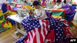 2018年7月13日,中国员工在安徽省阜阳的一家工厂缝制美国国旗。(资料照)