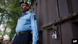 A Pakistani police officer stands guard outside a sealed Save the Children office in Islamabad, Pakistan, June 12, 2015.