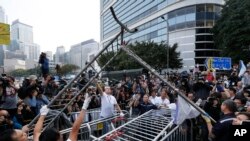 Workers start clearing away barricades at an occupied area outside government headquarters in Hong Kong, Nov. 18, 2014.