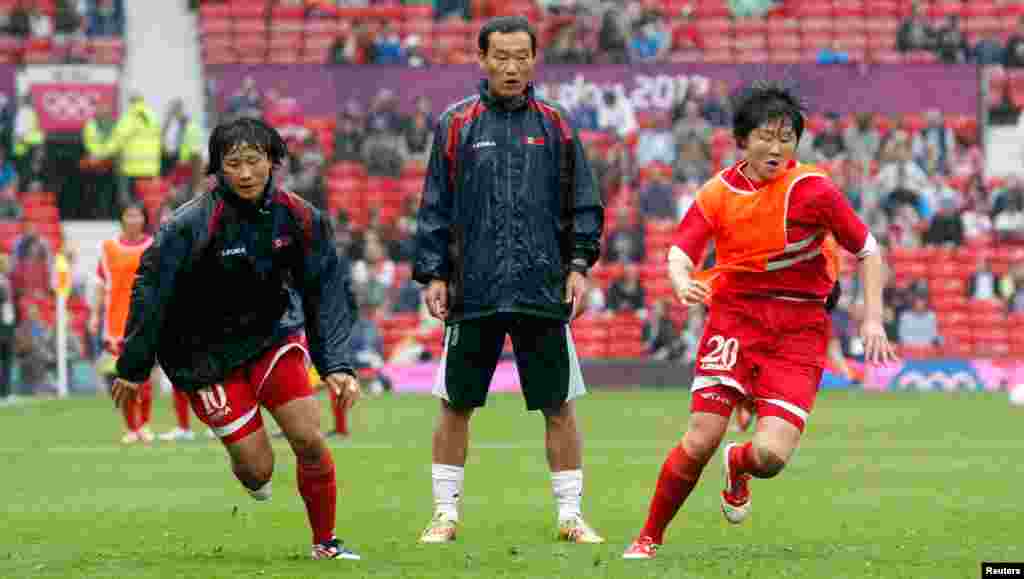 Các vận động viên Bắc Triều Tiên Yun Hyon-hui và Yong Sim-choe vận động trước khi thi đấu trận bóng tròn nữ vòng đầu, Nhóm G, với đội tuyển Hoa Kỳ.