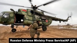 俄罗斯国防部今年2月19日发布的照片显示,一名俄罗斯海军陆战队士兵正在白俄罗斯一个训练基地演练快速部署。这是勇气-2022军演的一部分。-照片由美联社提供。