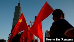 资料照:亲中人士在台北地标性建筑101大楼前高举中国国旗。