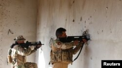 伊拉克安全部队以墙壁为掩护在摩苏尔已被同“伊斯兰国”交战。(2016年12月30日).