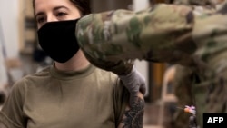 资料照片:驻韩美军发布的照片显示一名军人在首尔以南的乌山空军基地接种第一剂莫德纳新冠疫苗。(2020年12月29日)