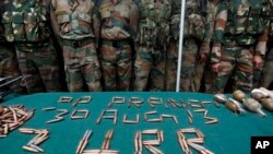 Binh sĩ Ấn Độ bên cạnh các vũ khí và đạn dược tịch thu được tại một căn cứ quân sự ở Prang, khoảng 45 km (28 dặm) về phía đông bắc Srinagar, Ấn Độ, ngày 30/8/2013.