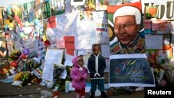 Trẻ em chụp hình bên ngoài Bệnh viện nơi cựu Tổng thống Nam Phi Nelson Mandela đang được điều trị ở Pretoria, Nam Phi, ngày 27/6/2013.
