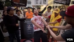 洛杉矶民主人士10月6日举行集会支持美众院通过《阻止中共法》,抗议中共暴行。抗议者通过行动剧展示中共酷刑之一开大门:左右口腔拉开强制灌药、口腔里丢烟头、吐痰,拉手铐手关节直至脱臼叫拔河比赛。-张木林2024年10月6日拍摄