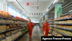 2021年10月20日,朝鲜首都平壤一家百货店工作人员在喷洒预防新型冠状病毒的消毒剂。(法新社)