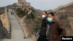 北京八达岭长城重新开放第一日,戴着口罩的游人游长城。(2020年3月24日)