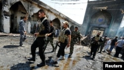 Các chiến binh Shia từ Saraya al-Salam đến hiện trường vụ đánh bom đền thờ Hồi giáo Shia Sayid Mohammed bin Ali al-Hadi ở Balad, phía bắc Baghdad, Iraq, ngày 8/7/2016.