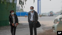 北京公益志愿者陈玫的母亲(左)和北京公益志愿者蔡伟的父亲为旁听他们儿子的庭审到达北京一家法院外。(2021年5月11日)