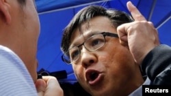 香港立法会亲北京议员何君尧在与一名民主派议员辩论。(2019年8月12日)