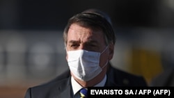 资料照:巴西总统贾尔·博尔索纳罗(Jair Bolsonaro)在巴西利亚阿尔沃拉达宫举行部长级会议前举行升旗仪式时戴着口罩。(2020年5月12日)