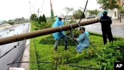Công nhân điện lực đang sửa chữa cột điện đổ ở tỉnh Phú Yên, miền trung Việt Nam, hôm 4/11, sau khi Damrey tràn qua.