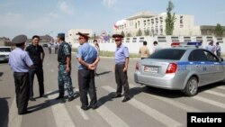 吉尔吉斯调查人员,内务部官员和警察在遇袭的中国驻吉尔吉斯斯坦大使馆附近(2016年8月30日)