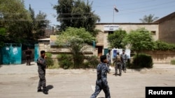 Cảnh sát đứng canh tại một phòng phiếu ở Baghdad, Iraq, 19/4/13