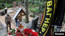 人们站在俄罗斯圣彼得堡普里戈津的墓地前。(2023年8月30日)