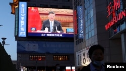 资料照片:北京街头屏幕显示中国国家主席习近平出席气候变化视频峰会(2021年4月16日)