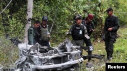 Nhân viên an ninh Thái Lan vây quanh đống đổ nát của một chiếc xe được dùng trong vụ đánh bom ở tỉnh Yala, ngày 10/2/2013.