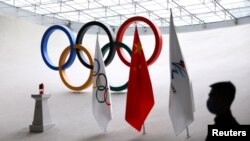 一名保安在北京奥运大厦中守卫奥运火种和旗帜。(2021年12月10日)