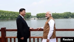 2018年4月28日,中国国家主席习近平和印度总理纳伦德拉·莫迪在中国武汉沿东湖漫步时交谈。(印度新闻局通过路透社发布的照片)