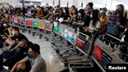 在香港机场,示威者们站在由手推车组成的路障前示威。(2019年8月13日)