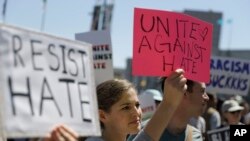 一位女性在旧金山的集会上举着标牌。(2017年8月25日)