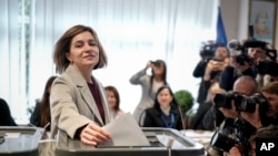 亲西方的现任总统桑杜在媒体围观下投入选票,虽然她遥遥领先10名竞争对手,但如果她未能达到50%的直接获胜门槛,将进行第二轮投票。(美联社:2024年10月20日)