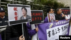 资料照:香港抗议者在北京驻香港机构中联办前手举铜锣湾书店失踪老板桂民海的照片。 (2016年1月19日)