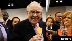 资料照 - 伯克希尔哈撒韦公司(Berkshire Hathaway)董事会主席兼总裁沃伦·巴菲特(Warren Buffett)在他创建的公司的年度会议上津津有味地享用着知名冰激凌甜品“冰雪皇后”。照片摄于2017年5月6日,内布拉斯加州的奥马哈市(Omaha, Nebraska)。