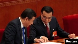 2015年3月5日中国国家主席习近平(左)和总理李克强(右)在全国人大全体会议开幕时交谈