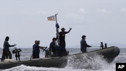 Ashton Eaton of the U.S. gestures as he holds a giant $100,000 cheque for his world record in the men's decathlon during the 15th IAAF World Championships at the National Stadium in Beijing, China.