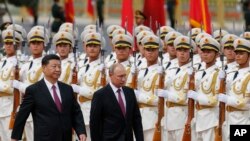 2018年6月8日北京人民大会堂外,俄罗斯总统弗拉基米尔·普京和中国国家主席习近平在欢迎仪式上检阅仪仗队。