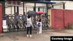 2019年6月28日下午,709家属李文足与儿子在临沂监狱会见室外面。(推特图片)