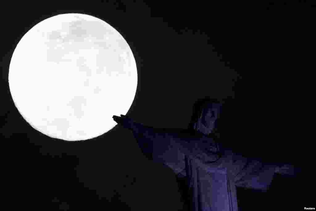 2018年2月1日,在巴西里约热内卢的基督救世主雕像旁边的“超级月亮”。这让人想起李白的乐府诗:“小时不识月, 呼作白玉盘。又疑瑶台镜, 飞在青云端。 ”